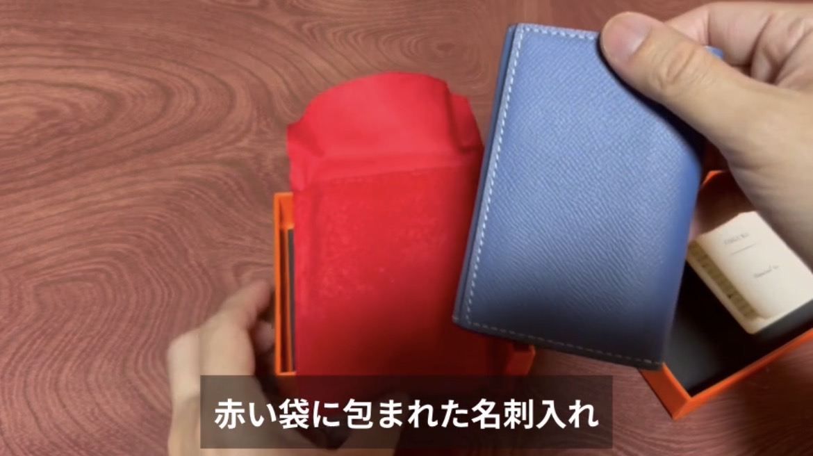 赤い袋から取り出したディープブルーのCOGURE名刺入れ