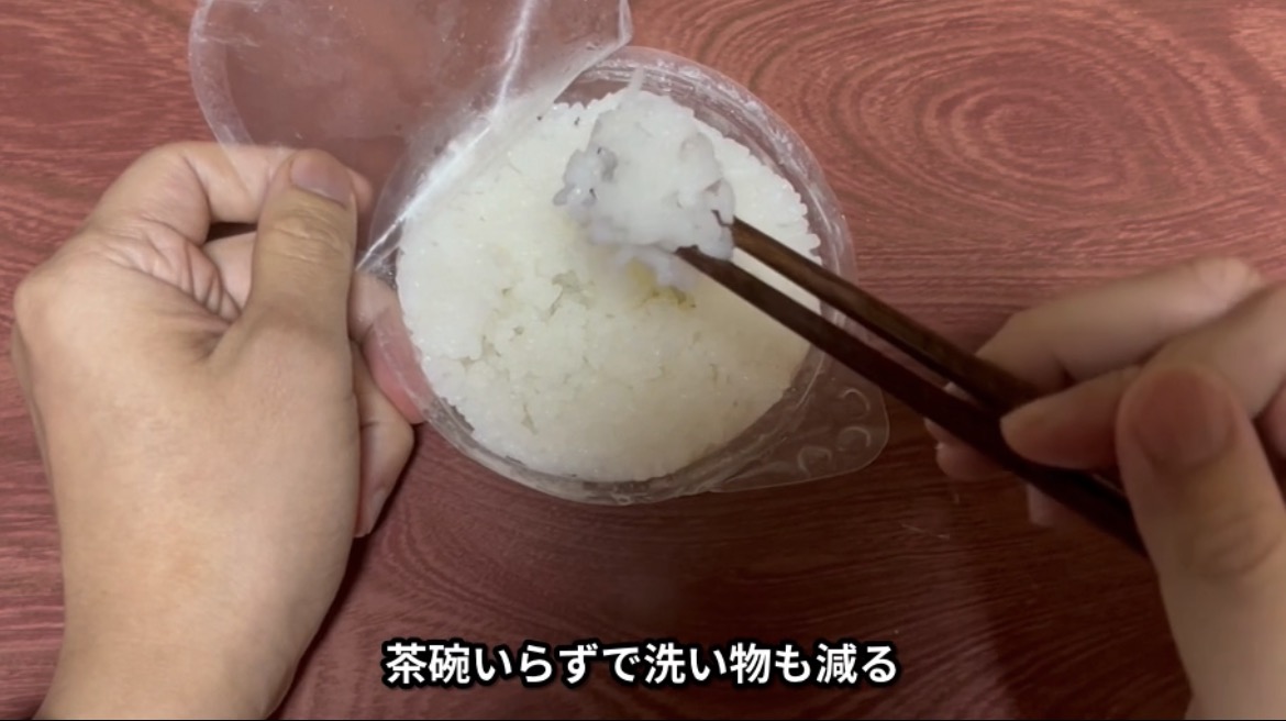 温めたご飯を容器から直接箸で食べているところ