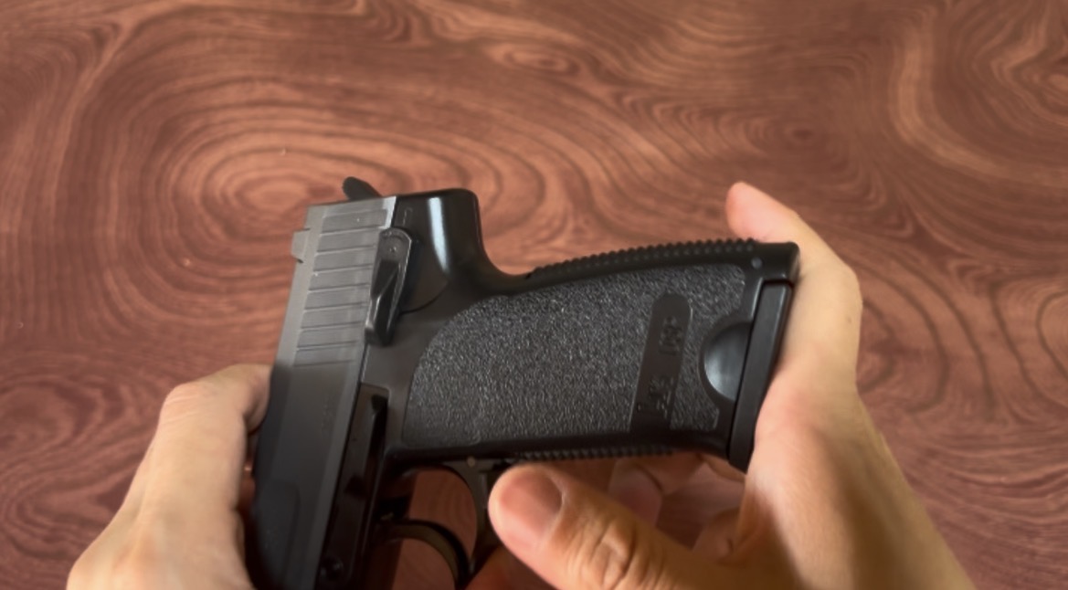 H&K USPを手で支え、グリップとスライド周辺を確認している様子